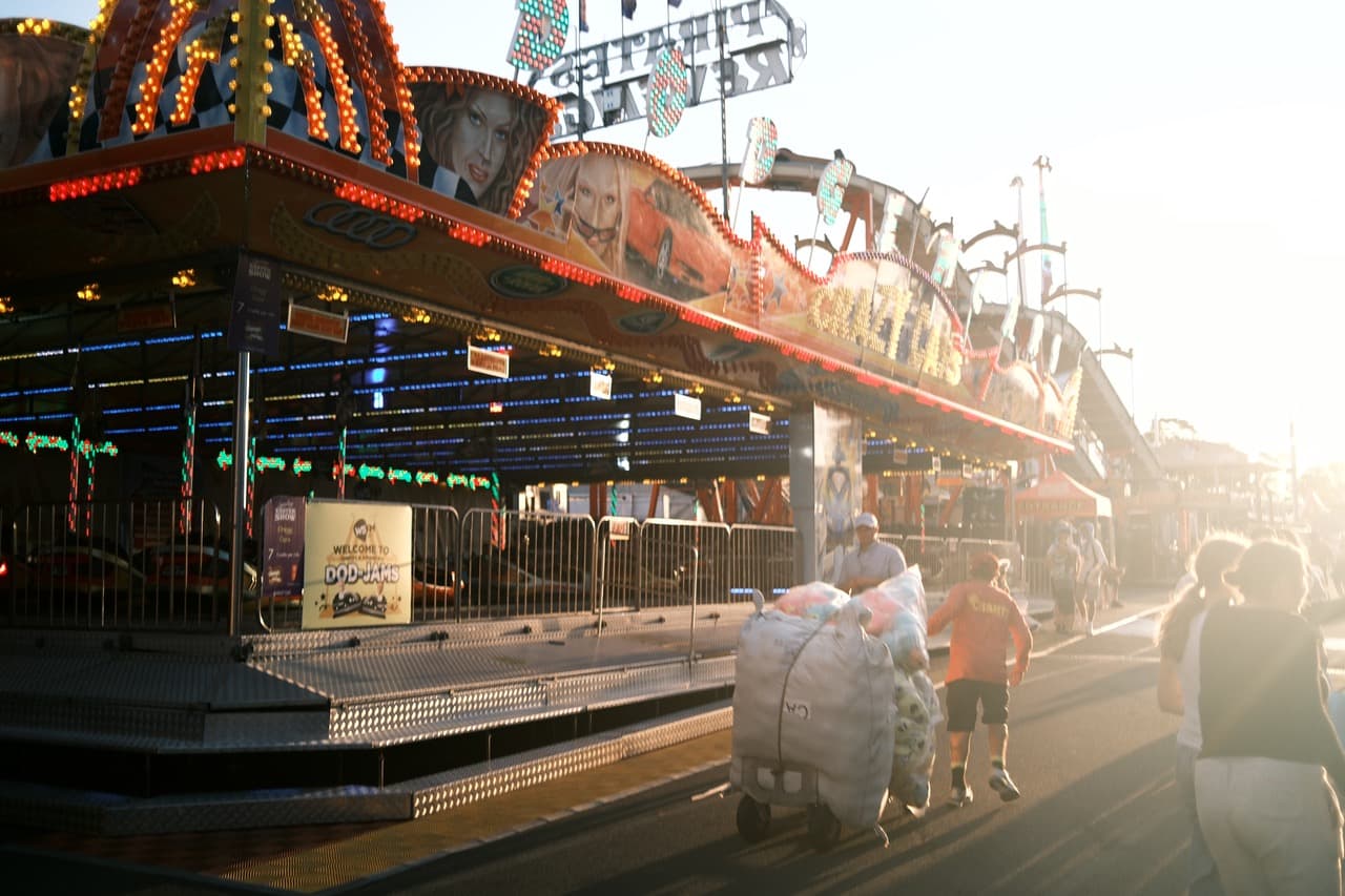 Golden hour at the Sydney Royal Easter Show — carnival rides and fairgoers silhouetted against warm light