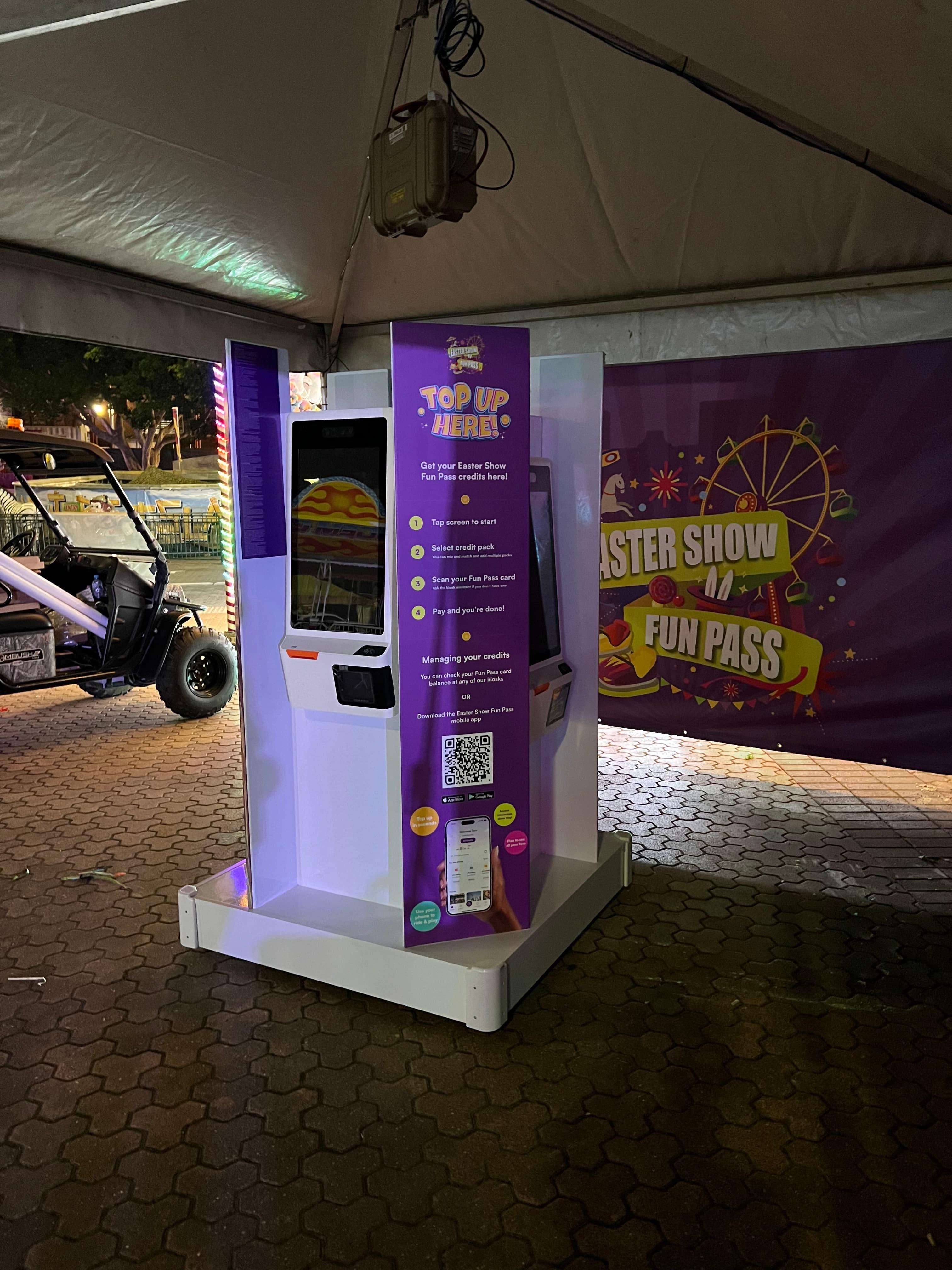 Kiosk being installed at the Easter Show — Fun Pass branding, NFC reader, and instructional wrap visible