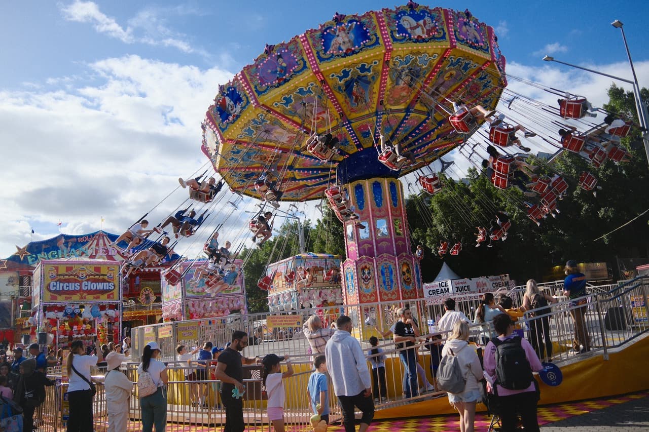 Chain swing carousel against blue sky with crowds below at the Easter Show